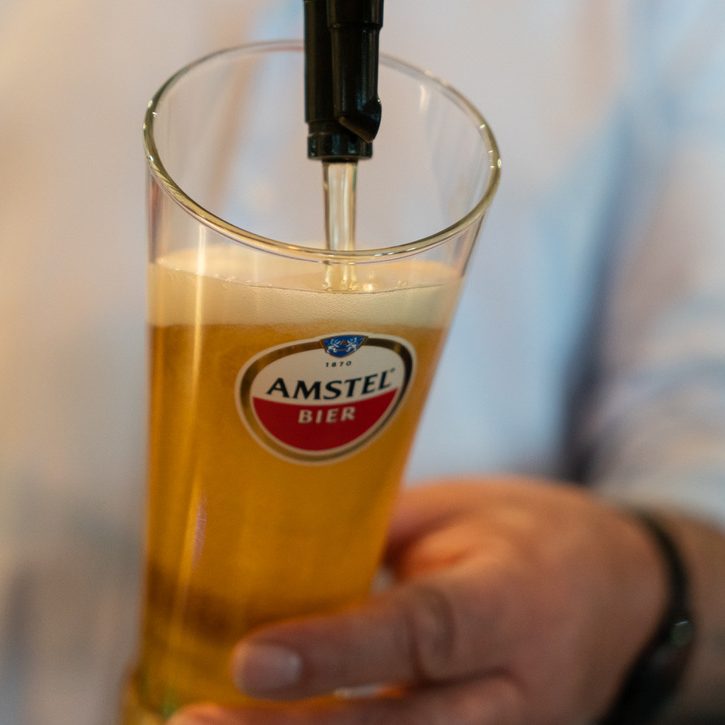 Picture of a member of staff pouring a pint of Amstel