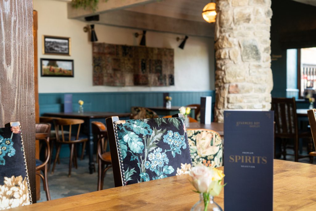 The Farmers Boy restaurant - luxury fabric seating to the forefront with an array of tables and stone columns in the background
