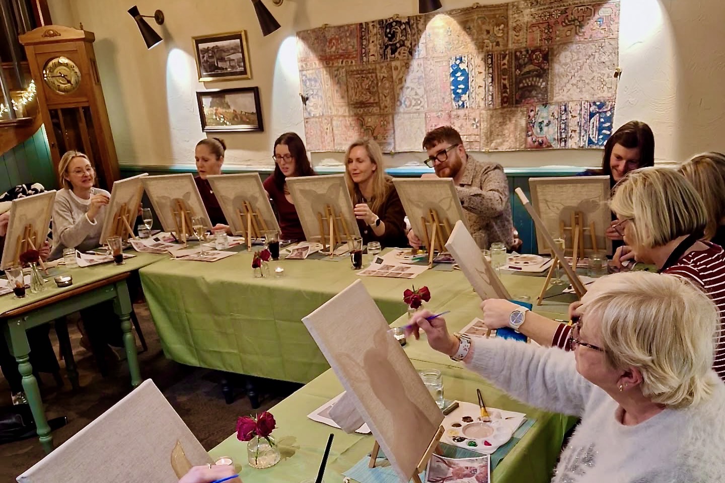 Sip and Paint event at The Farmers Boy. Group of attendees painting in front on canvases